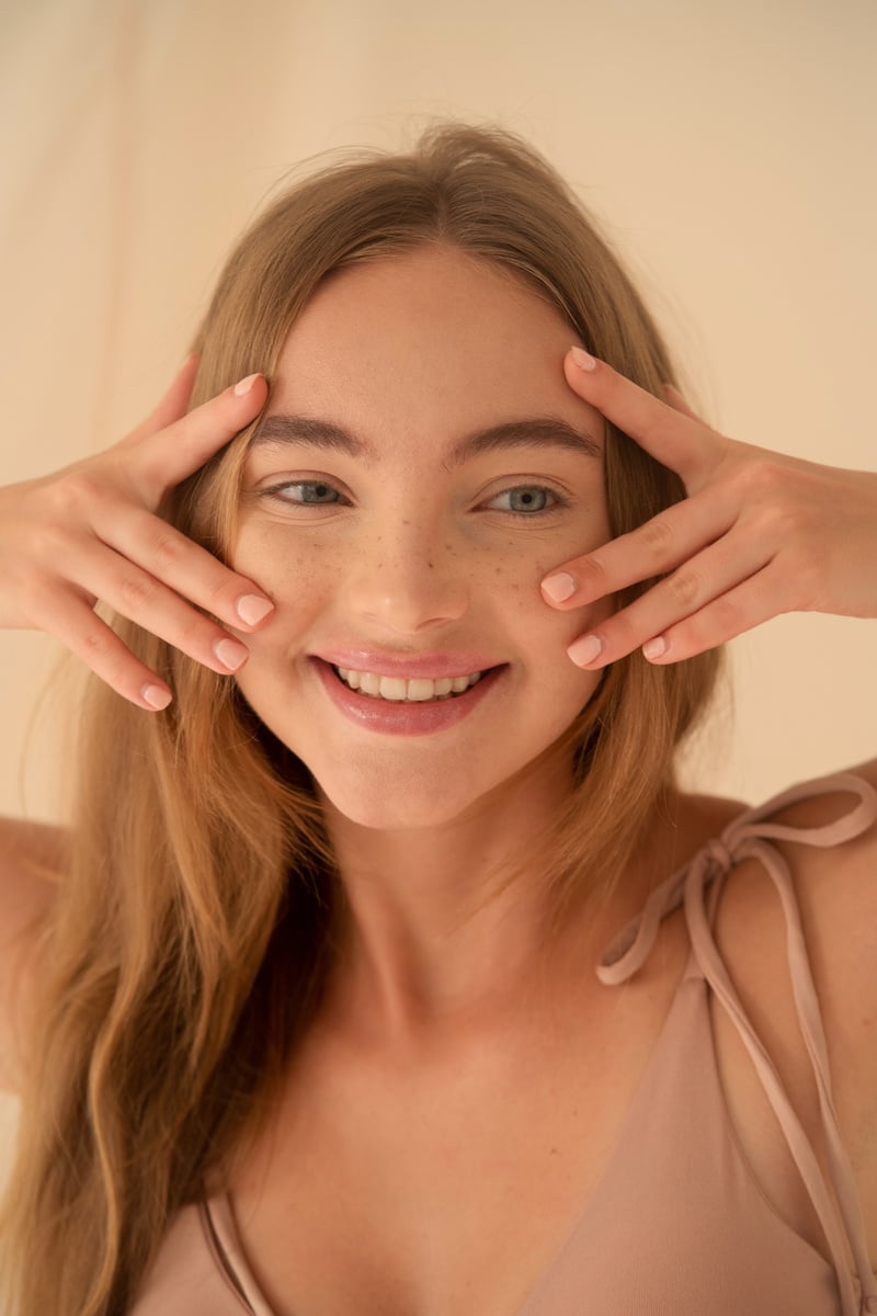 Smiling Woman with Freckles Touching Her Face